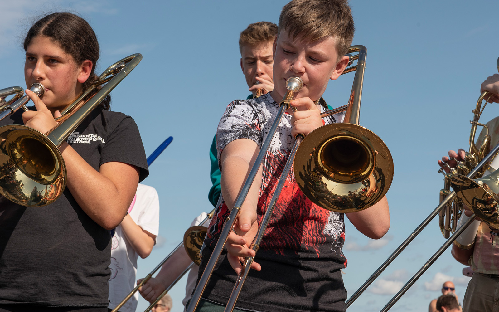 Young kids playing the trombone at a performance