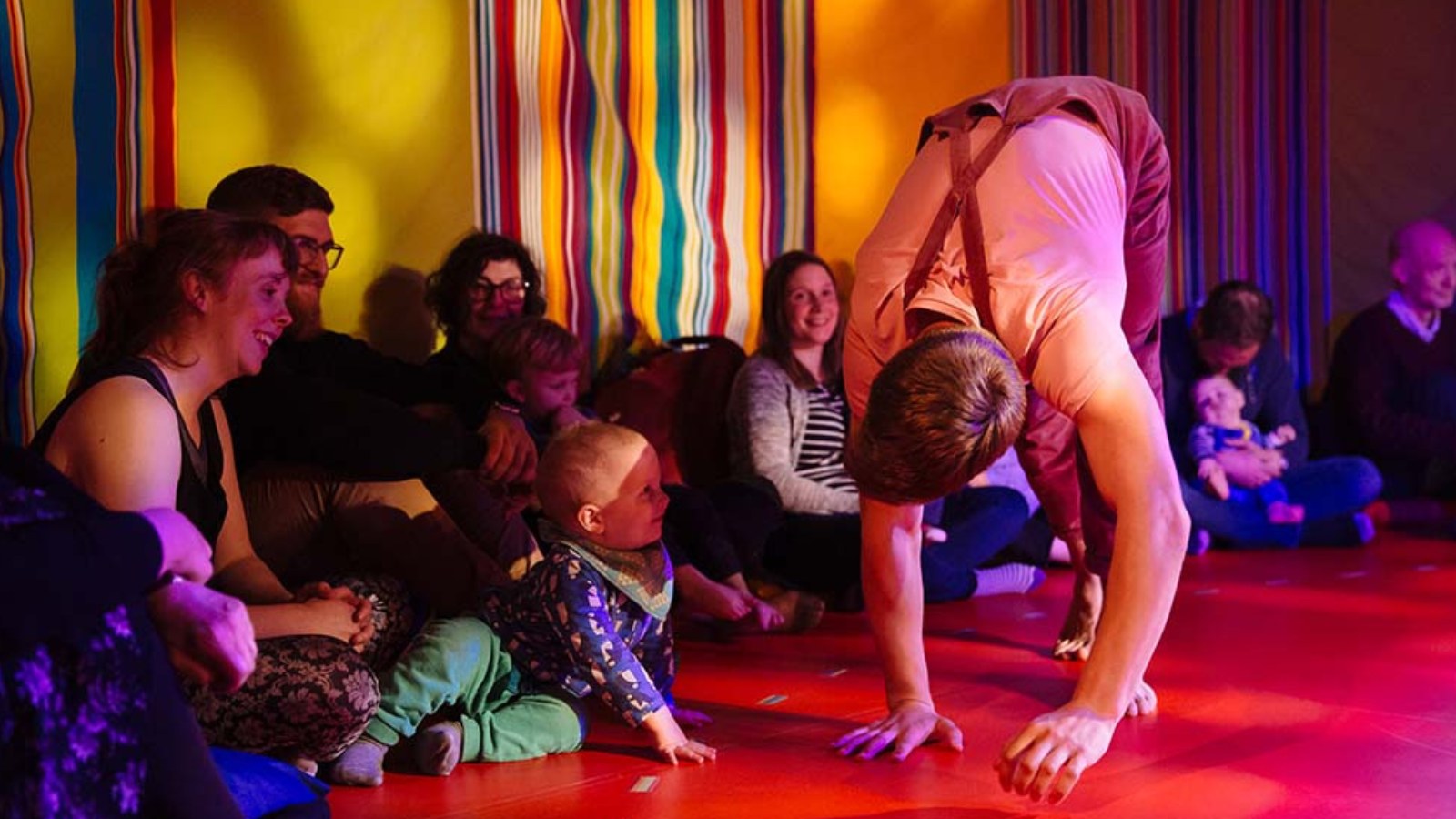 A performer folds over in front of a small child at a Starcatchers performance