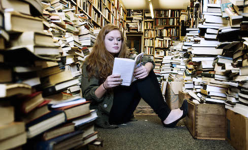 Teen girl reading in book shop