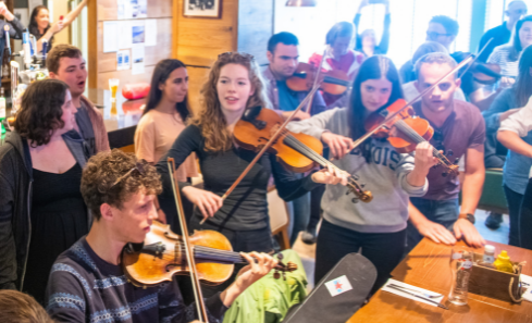 A group of young musicians stand holding their instruments in cafe