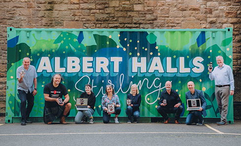 A group of people stand in front of a sign that says Albert Halls Stirling