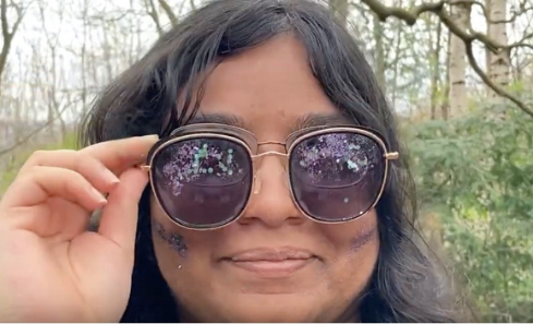 Shobhita holds a pair of sunglasses up - glitter is reflected in them
