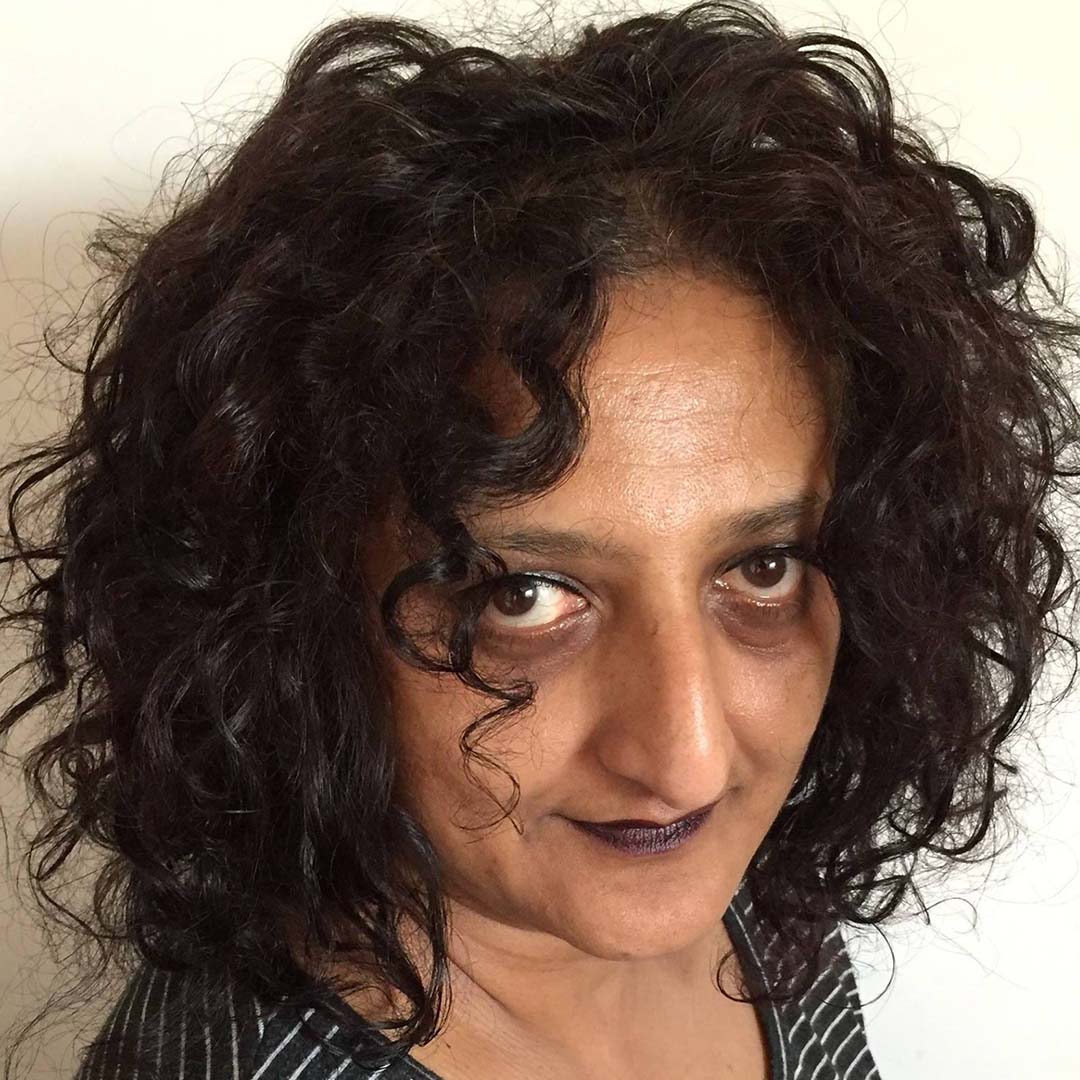 Headshot of a woman of Indian descent with short black hair - this is East Lothian-based Annie George