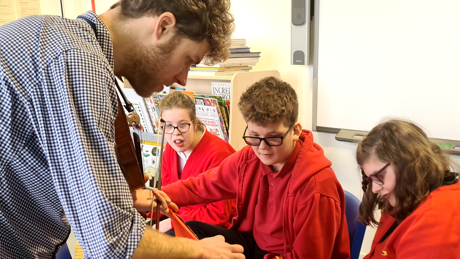 A DMS tutor shows young people how to use digital software during a session