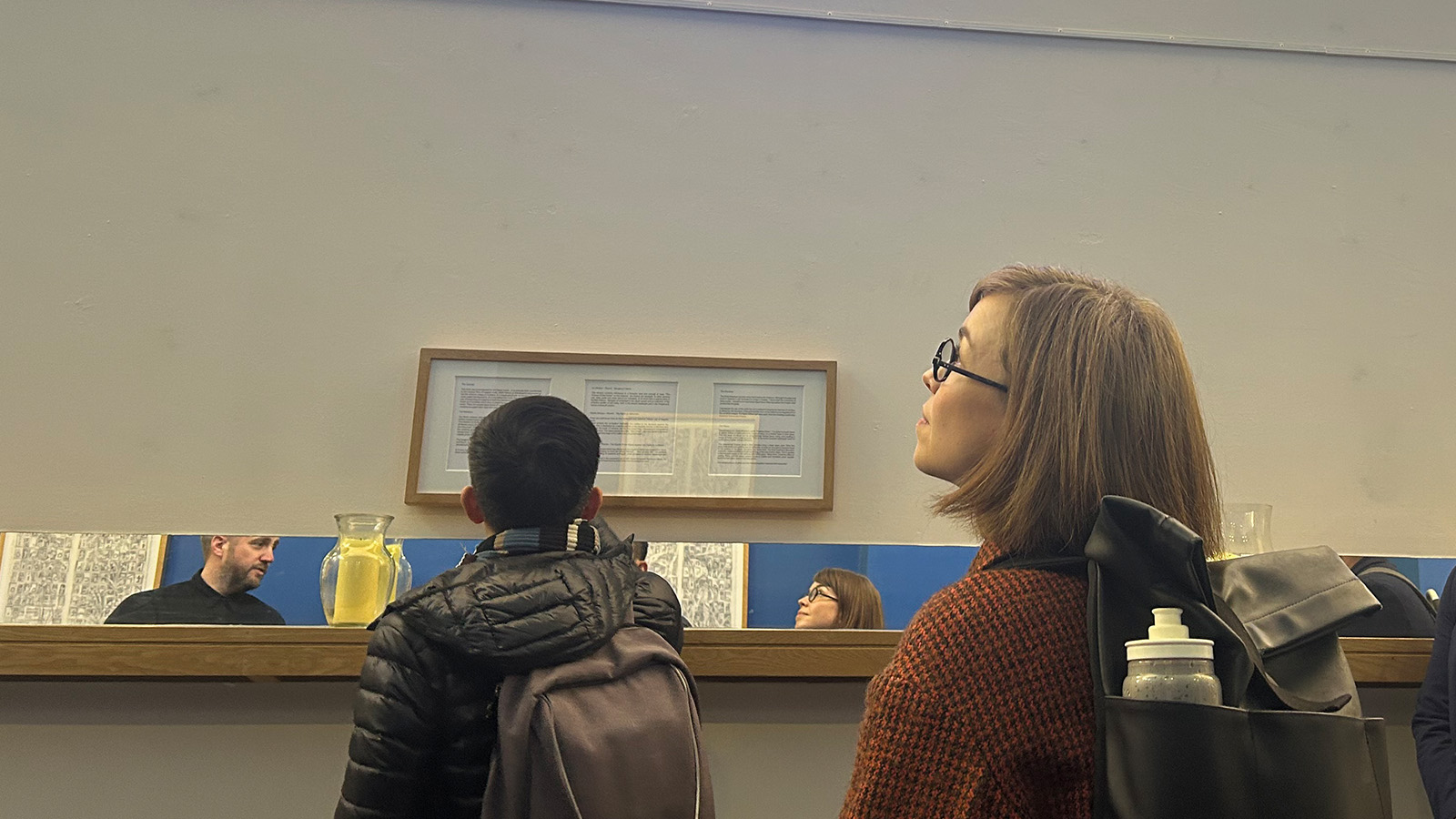 A woman looking around a large room with pieces of art on the wall