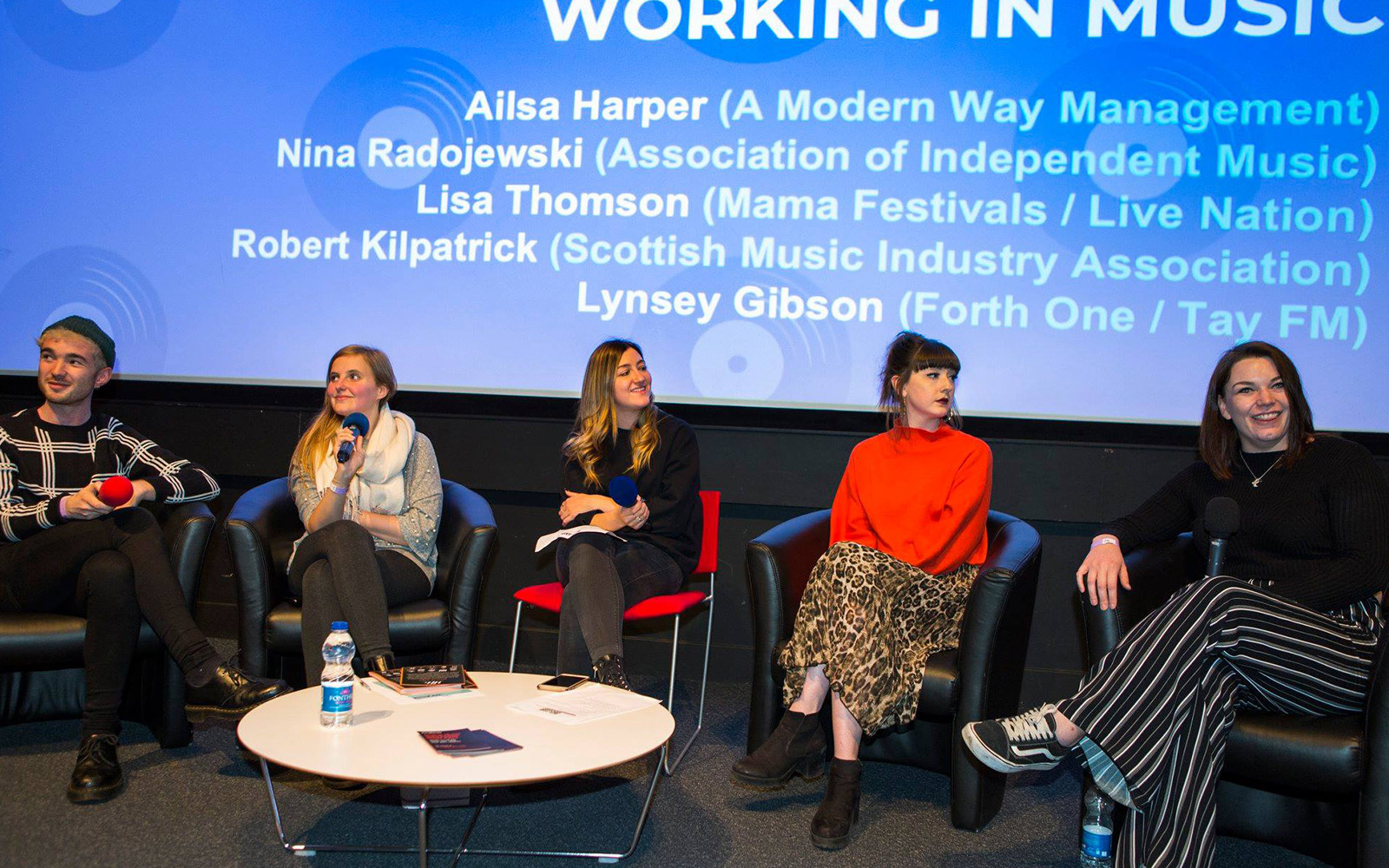 Panel members seated on a stage during an Off The Record event