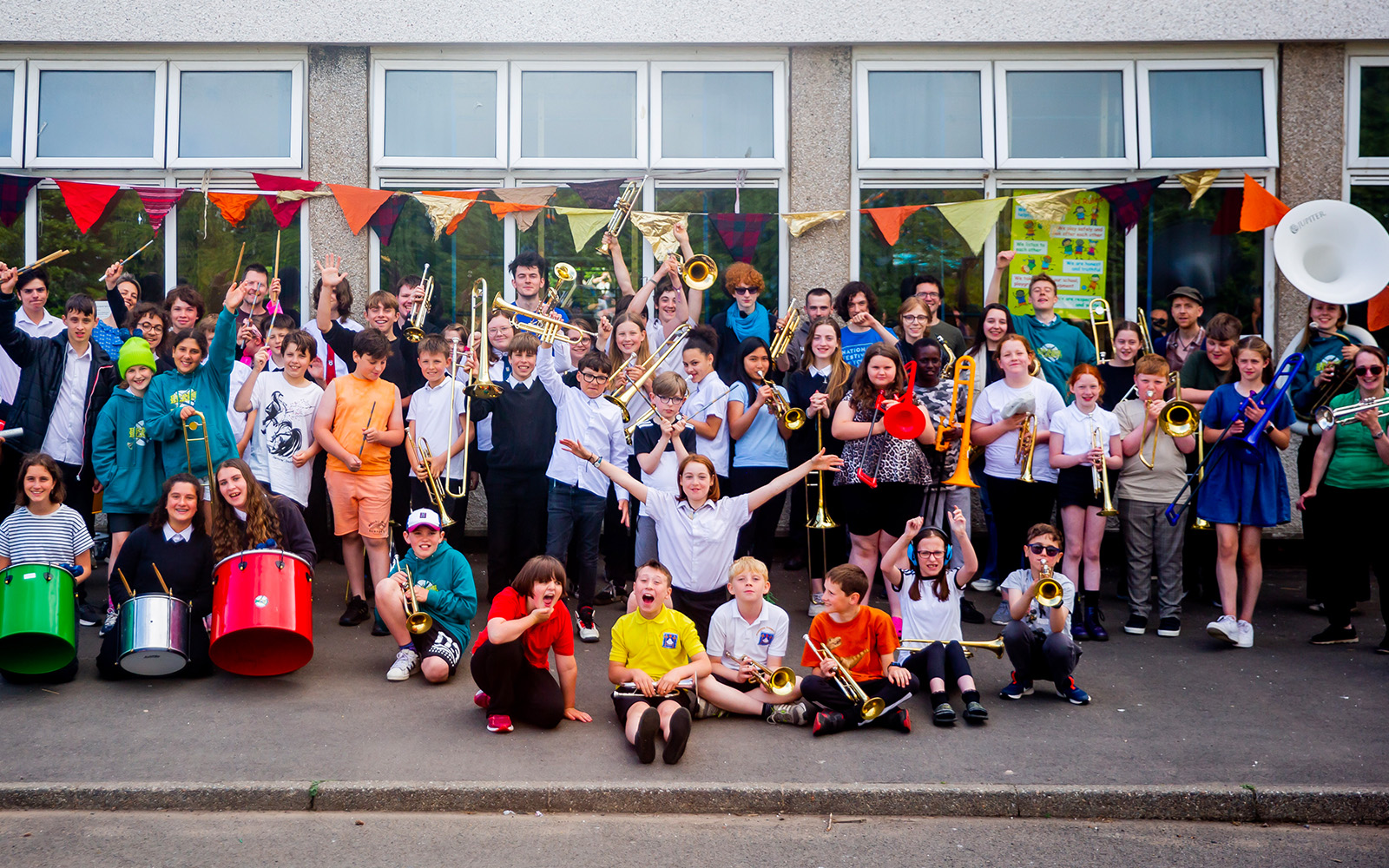 A large group of young children standing together holding brass instruments