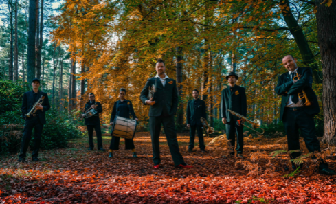 A band stand in a forest with autumnal trees behind them