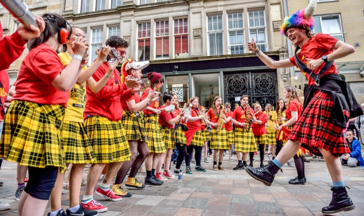 A group of drummers wearing colourful red tartan outfits