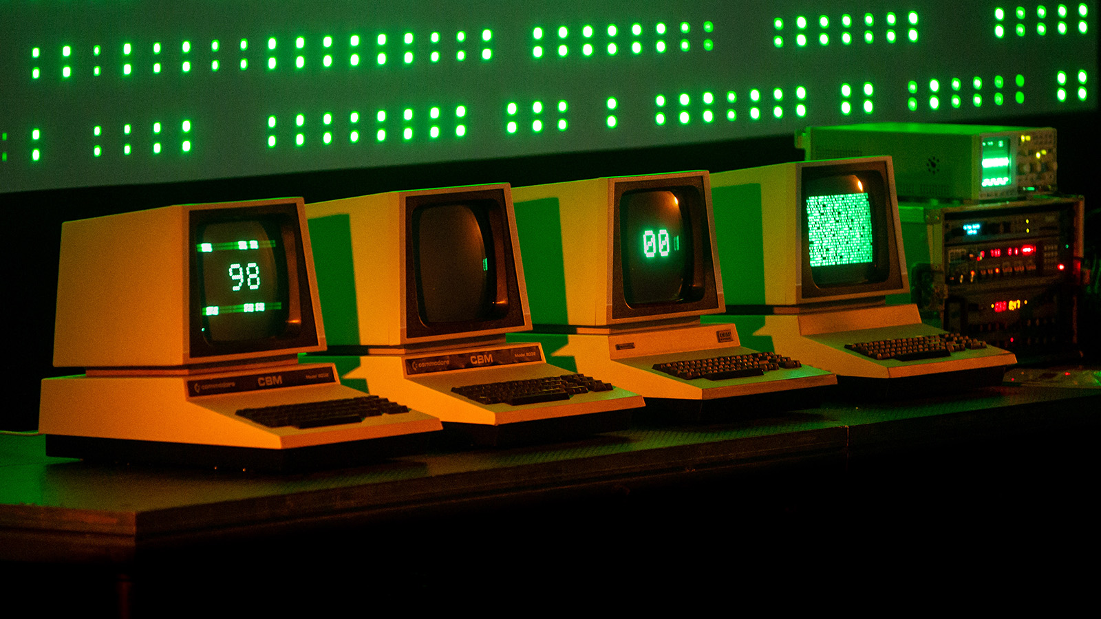 A bank of four computers which display numbers, dots and indecipherable code.