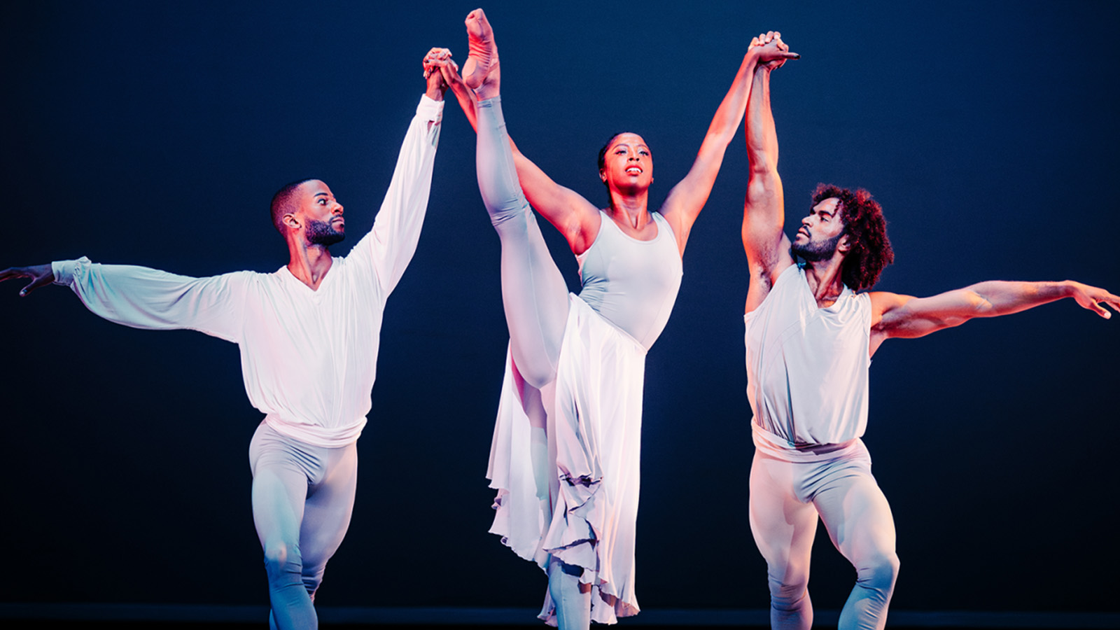 Alvin Ailey American Dance Theater at Edinburgh International Festival © Andrew Perry - ballet dancers on stage with two male dancers supporting a female dancer in the centre, who has her leg extended up past her head in the air