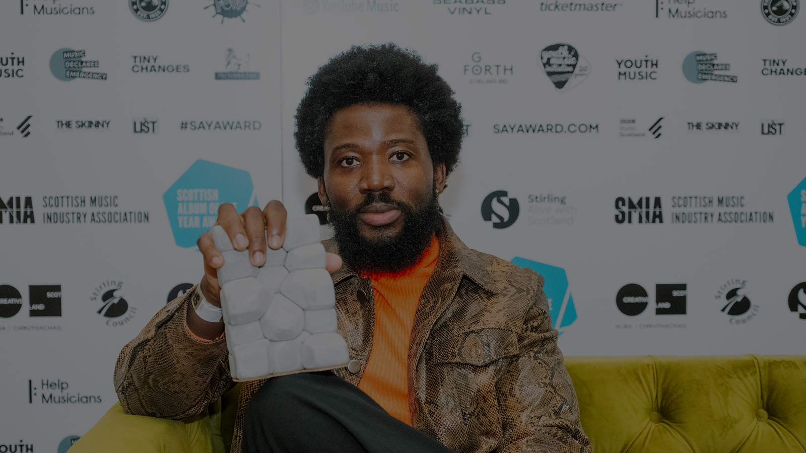 Young Fathers member Alloysious Massaquoi holds his award