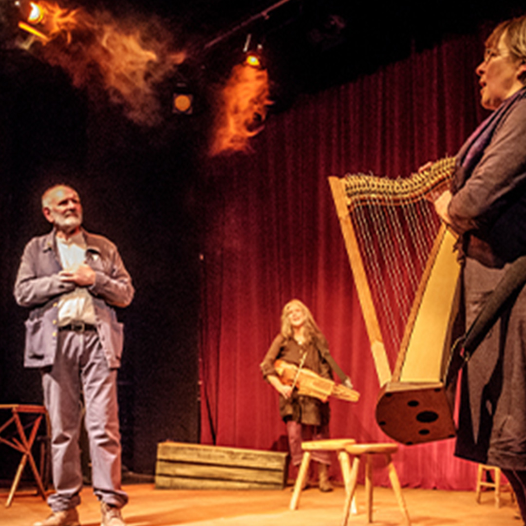 People stand on a stage with flames above them