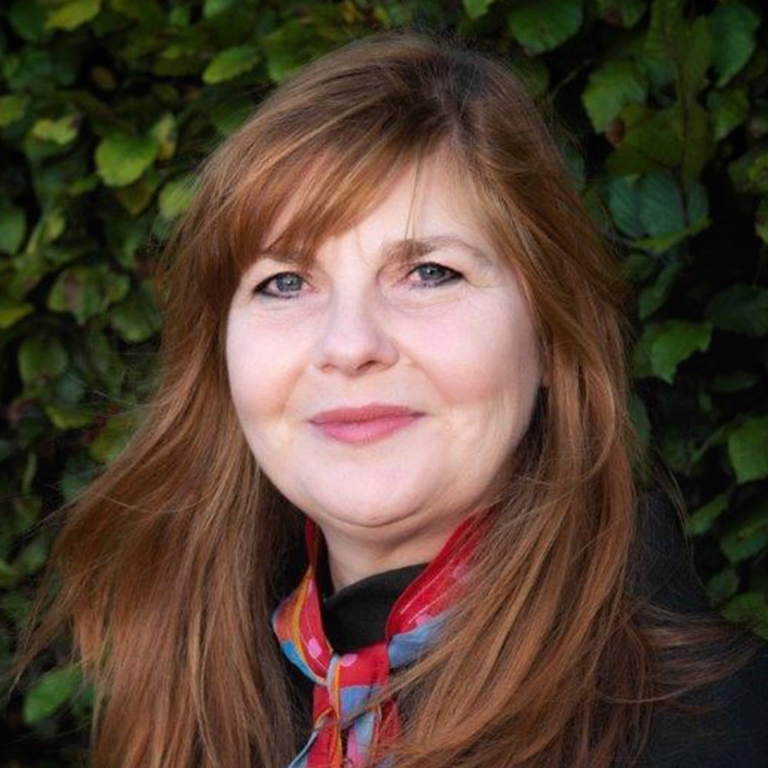 An image of Emma Nicolson who is a woman with longer reddish brown hair, smiling gently at the camera. Image by Suzy Higgins.