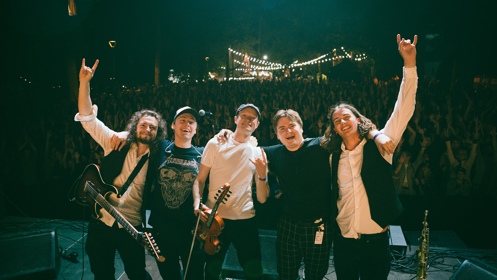 Members of Ganger pose in front of a large crowd at a gig