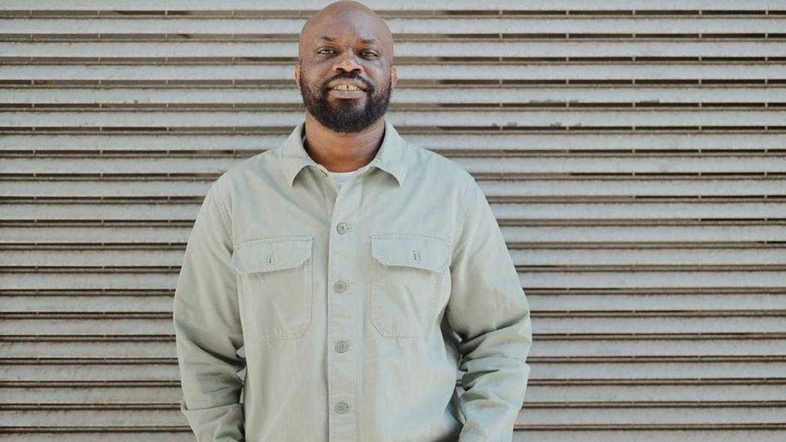 A Black man (Ica Headlam) wearing a light-coloured shirt